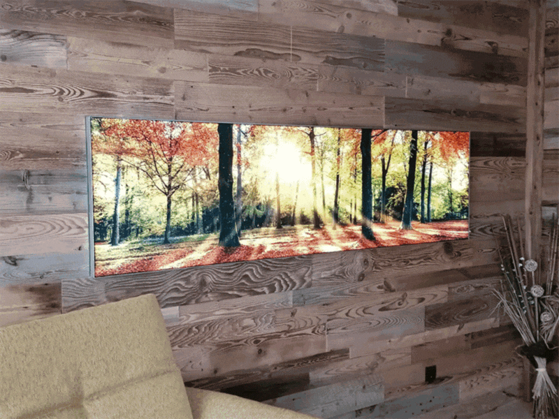 Leuchtbild im Wohnzimmer animiert mit Waldmotiv im Herbst